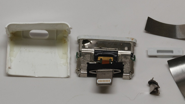 Apple's Lightning To 30-pin Adapter. Note the steel casing, peeled plastic, and scrap sheets of metal.